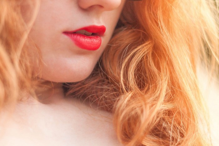 Close up of a woman with red hair and red lipstick