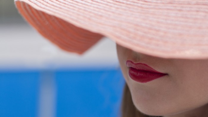 Woman wearing a pink hat with red lipstick