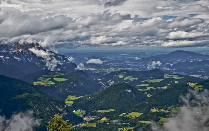 Aerial view of mountains and valleys under cloudy sky