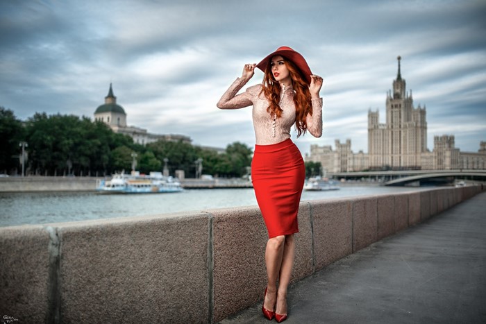 Woman in red hat and skirt by river in Moscow