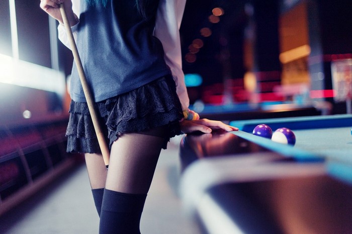 Woman playing billiards with blue hair