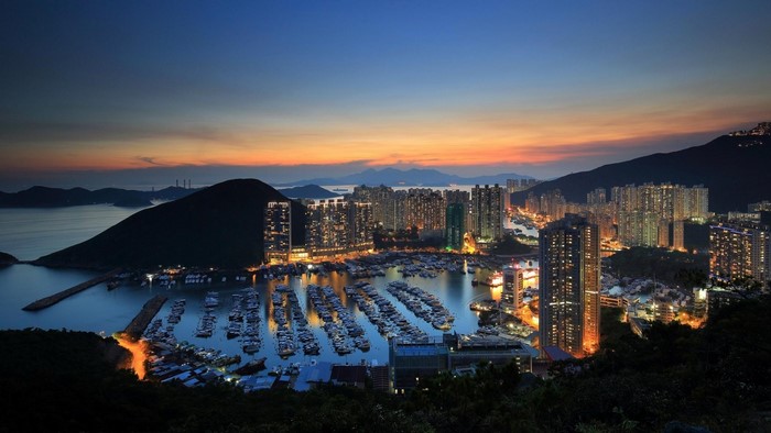 Cityscape with harbor and mountains at dusk