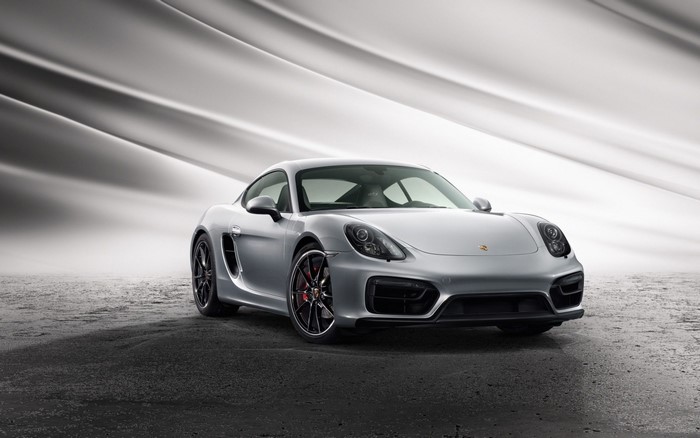 Silver Porsche Cayman S parked on a textured surface