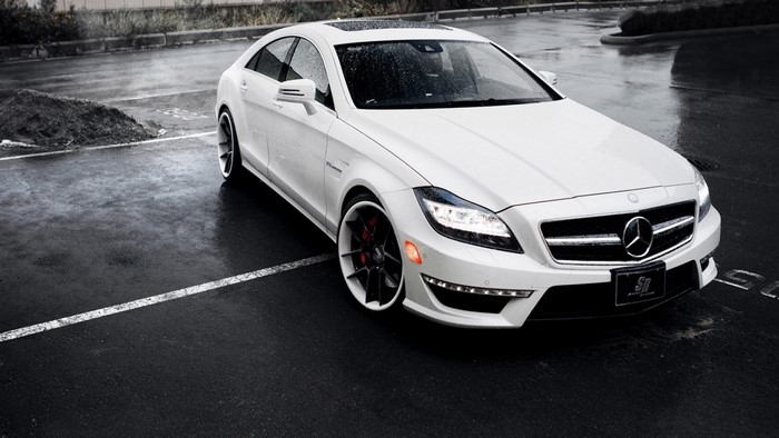 White Mercedes-Benz CLS 63 AMG parked on wet asphalt