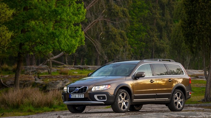 Brown Volvo XC70 parked in a forest