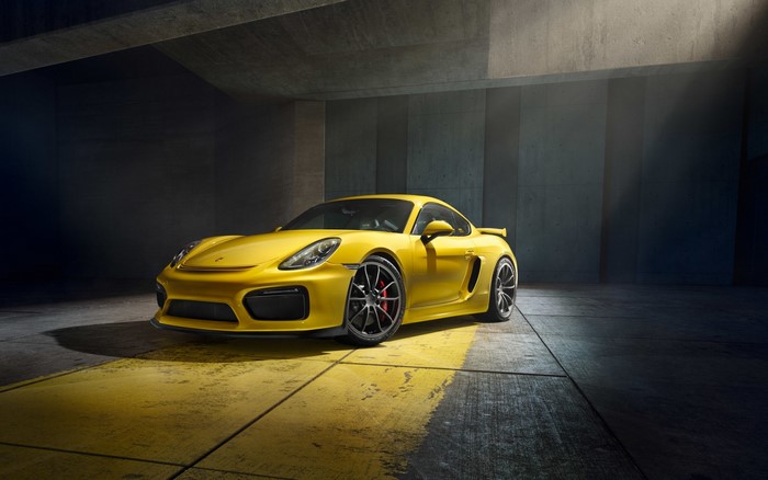 Yellow Porsche Cayman GT4 in a concrete garage