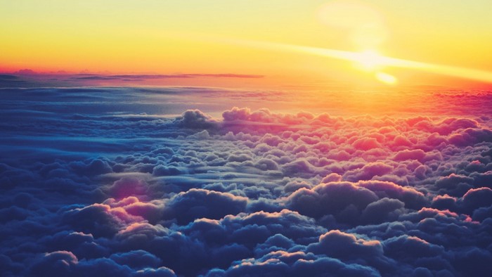 Sunset over clouds with sun rays