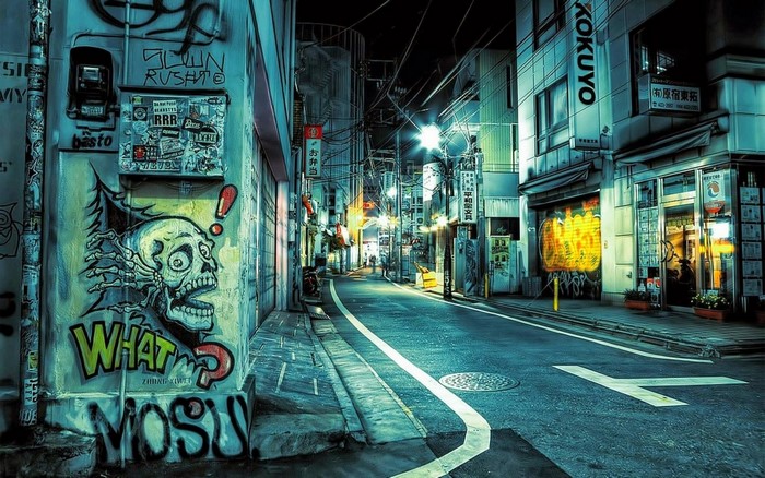 Graffiti-covered alleyway in a Japanese city at night