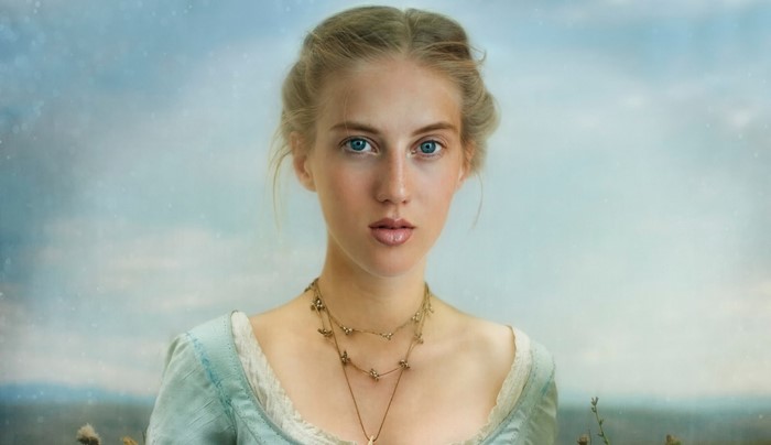 Woman with blue eyes and blonde hair wearing a necklace