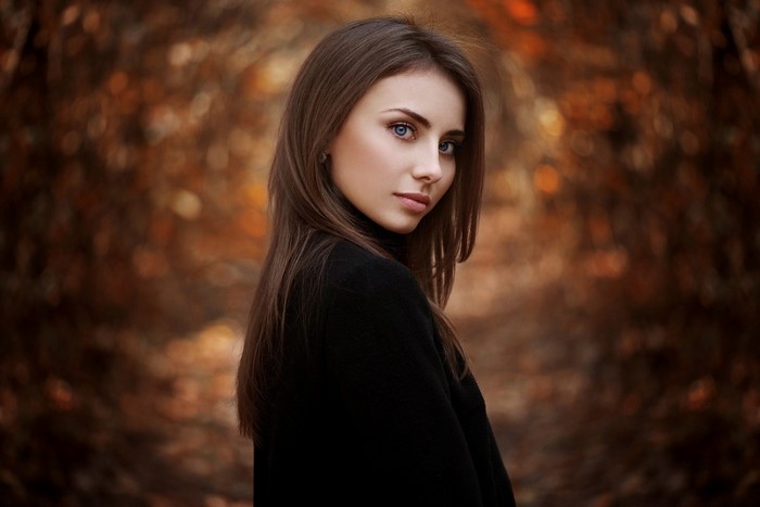 Woman with long brown hair and blue eyes in autumn