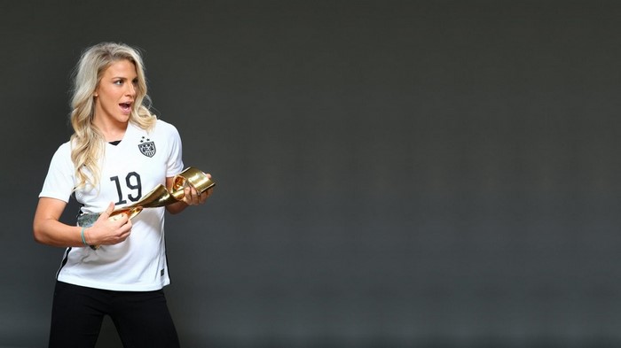 Julie Johnston holding a trophy