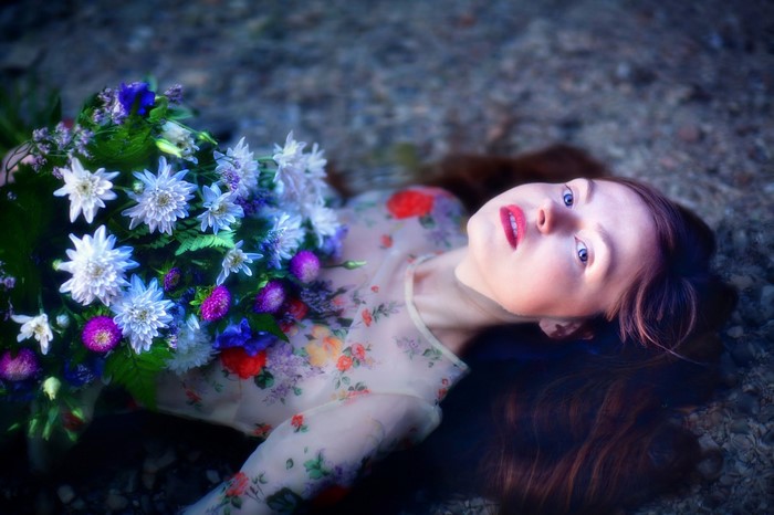 Woman lying down with a bouquet of flowers