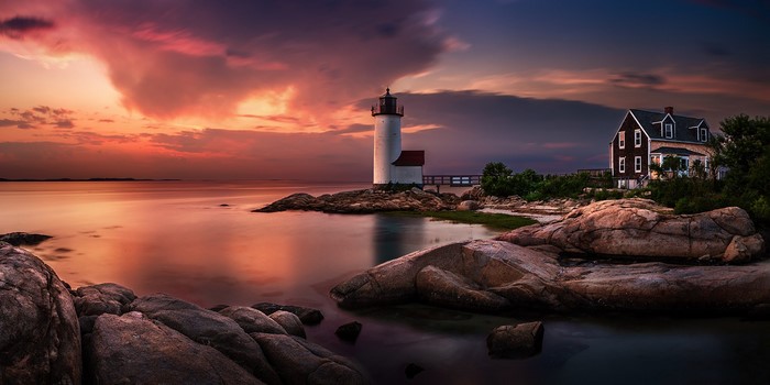 Massachusetts Lighthouse at Sunset Over Rocky Shore