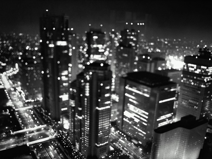 Monochrome cityscape at night with illuminated skyscrapers