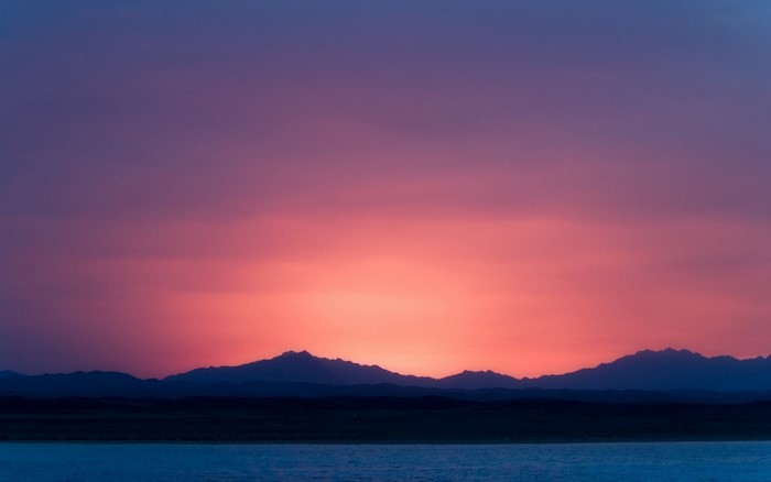Sunset over mountains and water
