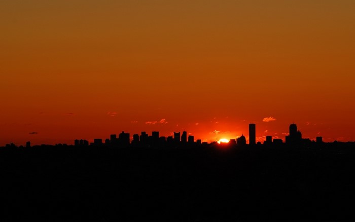 City skyline silhouetted against a vibrant sunset