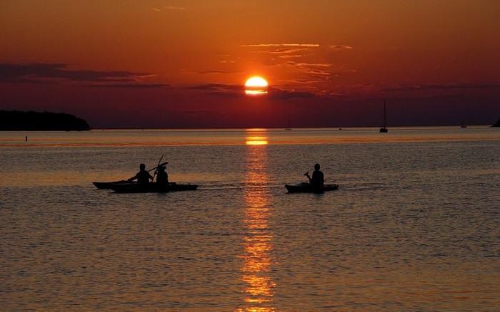 Kayakers on the sea at sunset