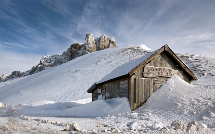Wooden souvenir shop in the snow, Dolomites mountains, Italy