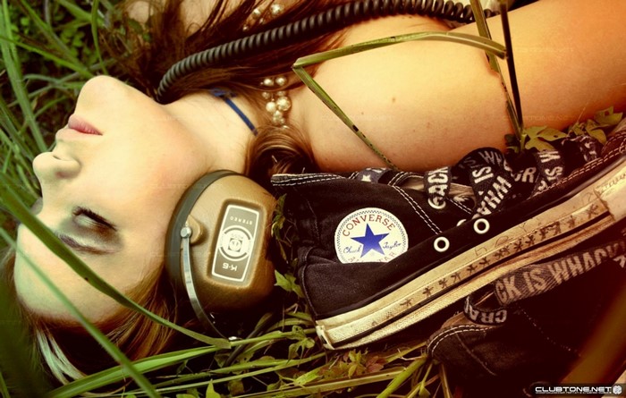 Woman wearing headphones and Converse sneakers