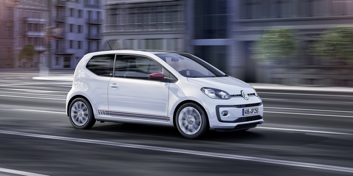 White Volkswagen up! "beats" driving on city street