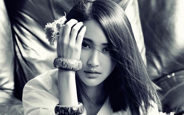 Monochrome portrait of a young Asian woman with a flower