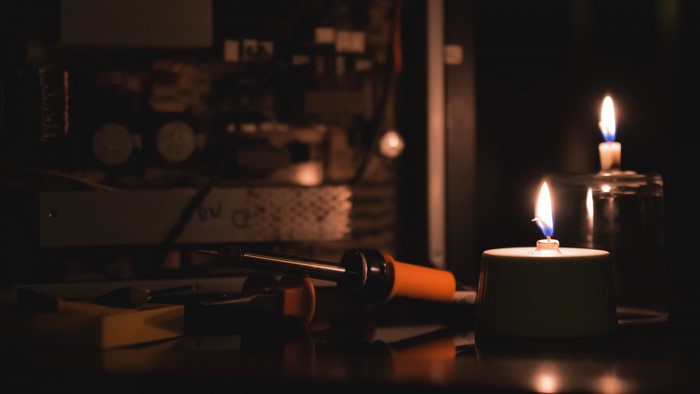 Soldering iron and candles in the dark