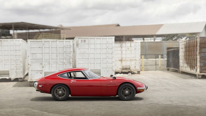 Red Toyota 2000GT sports car in industrial area