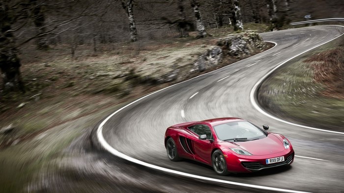 Red McLaren sports car on a winding road