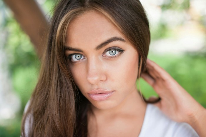 Close-up portrait of a young woman with blue eyes
