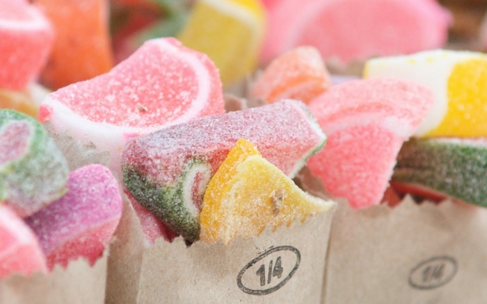 Assorted colorful gummy candies in paper bags