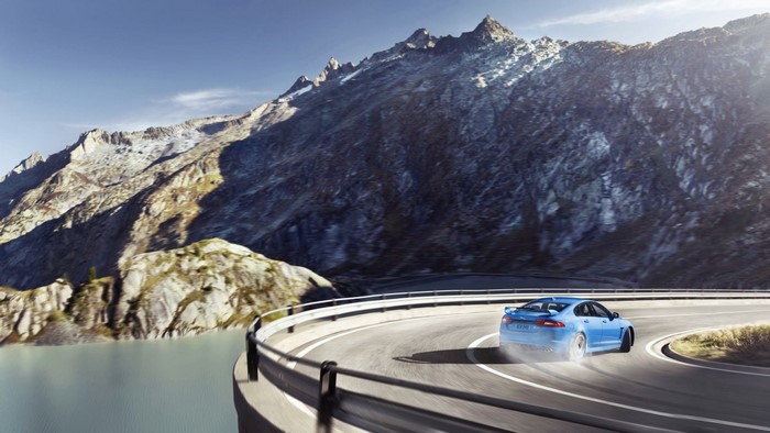 Blue Jaguar car drifting on a mountain pass road