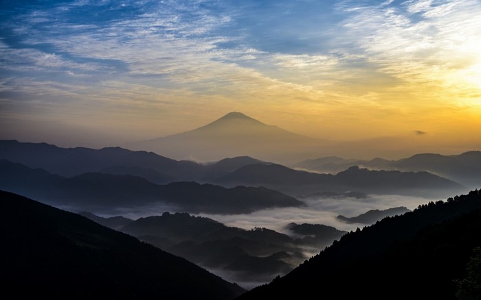 Mount Fuji at sunrise with mist and clouds