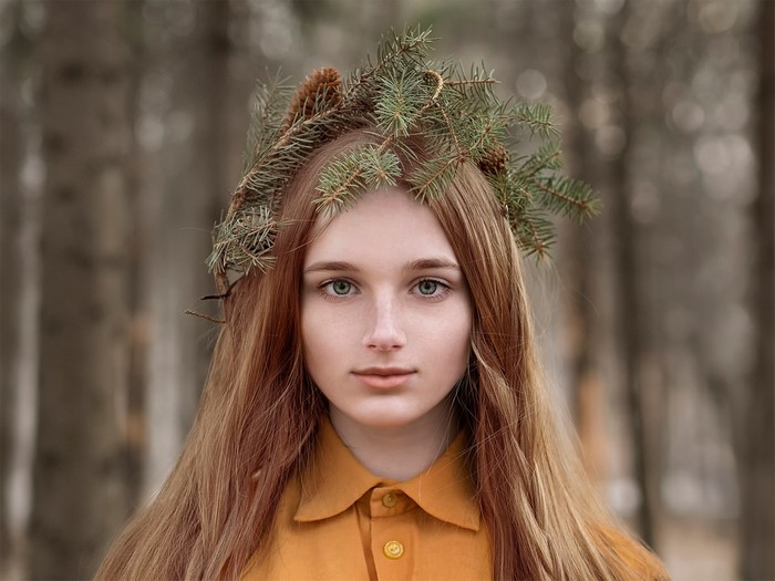 Woman with pine wreath in forest