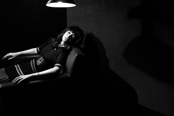 Woman in a chair under a lamp