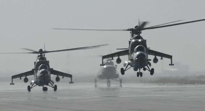Three Mil Mi-24 Hind helicopters on a runway