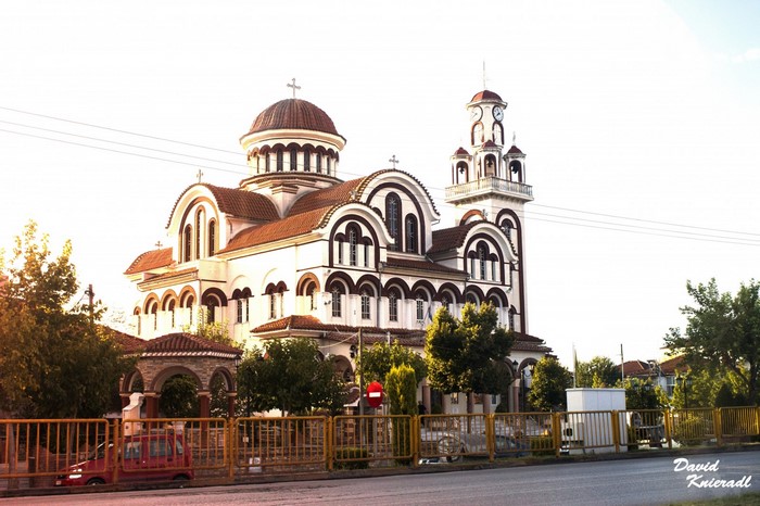 White church with red-tiled domes and bell tower