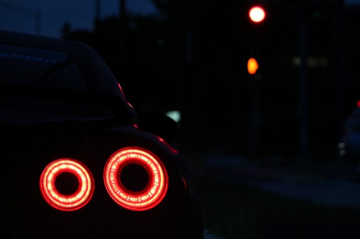 Nissan GTR taillights at night with traffic lights