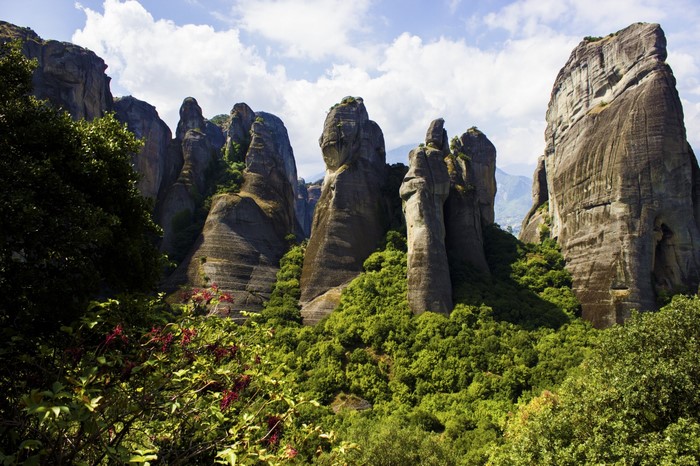 Meteora rock formations and lush greenery under a cloudy sky