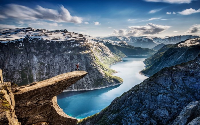 Person on Trolltunga cliff overlooking a fjord in Norway