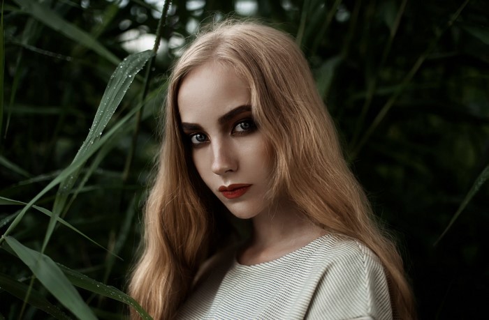 Woman with long blonde hair and dramatic makeup