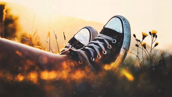 Person wearing Converse shoes in sunlight