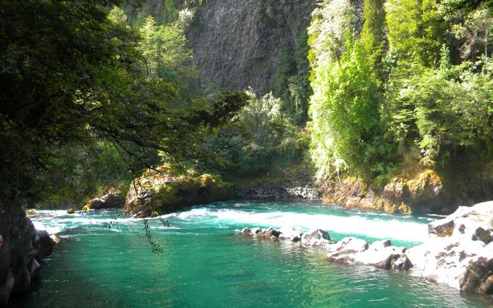 Turquoise river flowing through a rocky, forested gorge