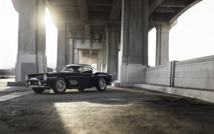 Dark blue Ferrari 250 GT California Spyder under a bridge