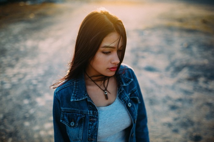Woman in denim jacket looking down
