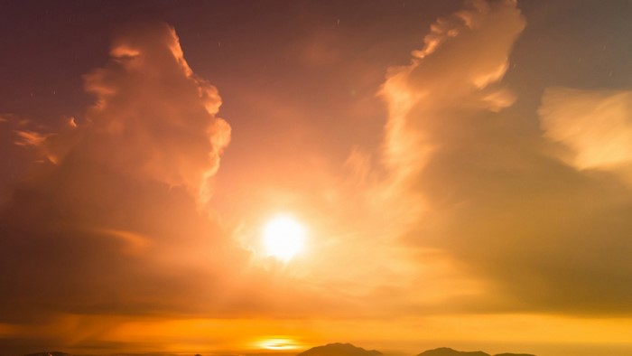 Sunset with clouds and mountains on the horizon