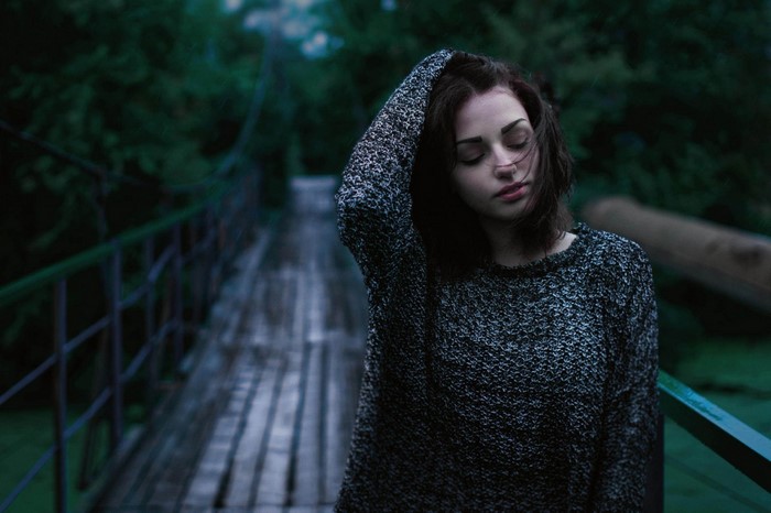 Woman with hand in hair on a bridge