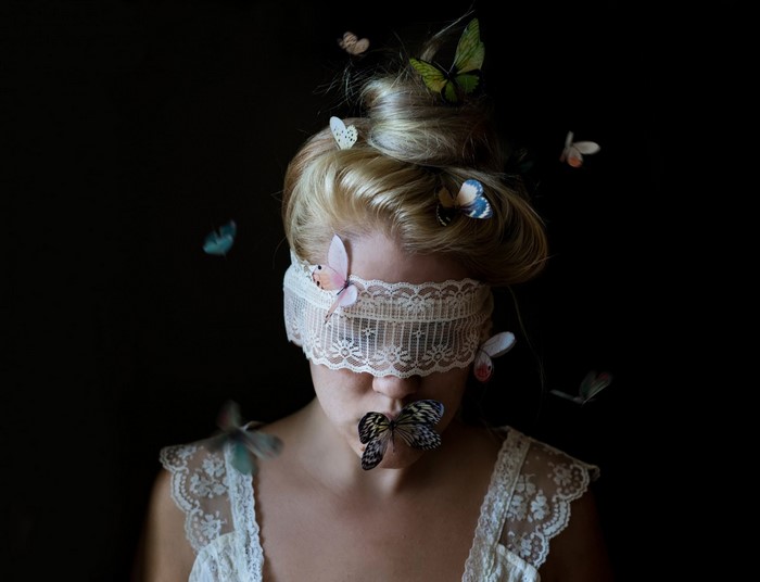 Woman with butterflies on face and head