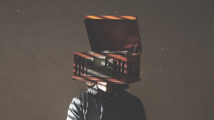 Person with a vintage phonograph on their head