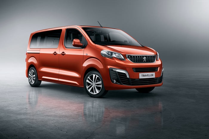 Orange Peugeot Traveller van on a grey background