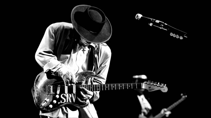 Stevie Ray Vaughan playing guitar on stage